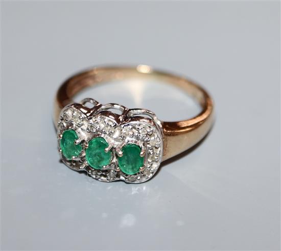 A 9ct gold, three stone emerald and diamond cluster ring, size O.